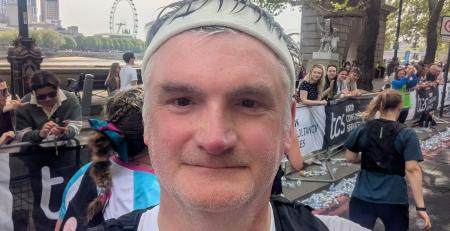 Law Society President Mark Evans taking a selfie at the end of the London Marathon. He is wearing a headband, and rucksack, and a t-shirt with the LawCare logo