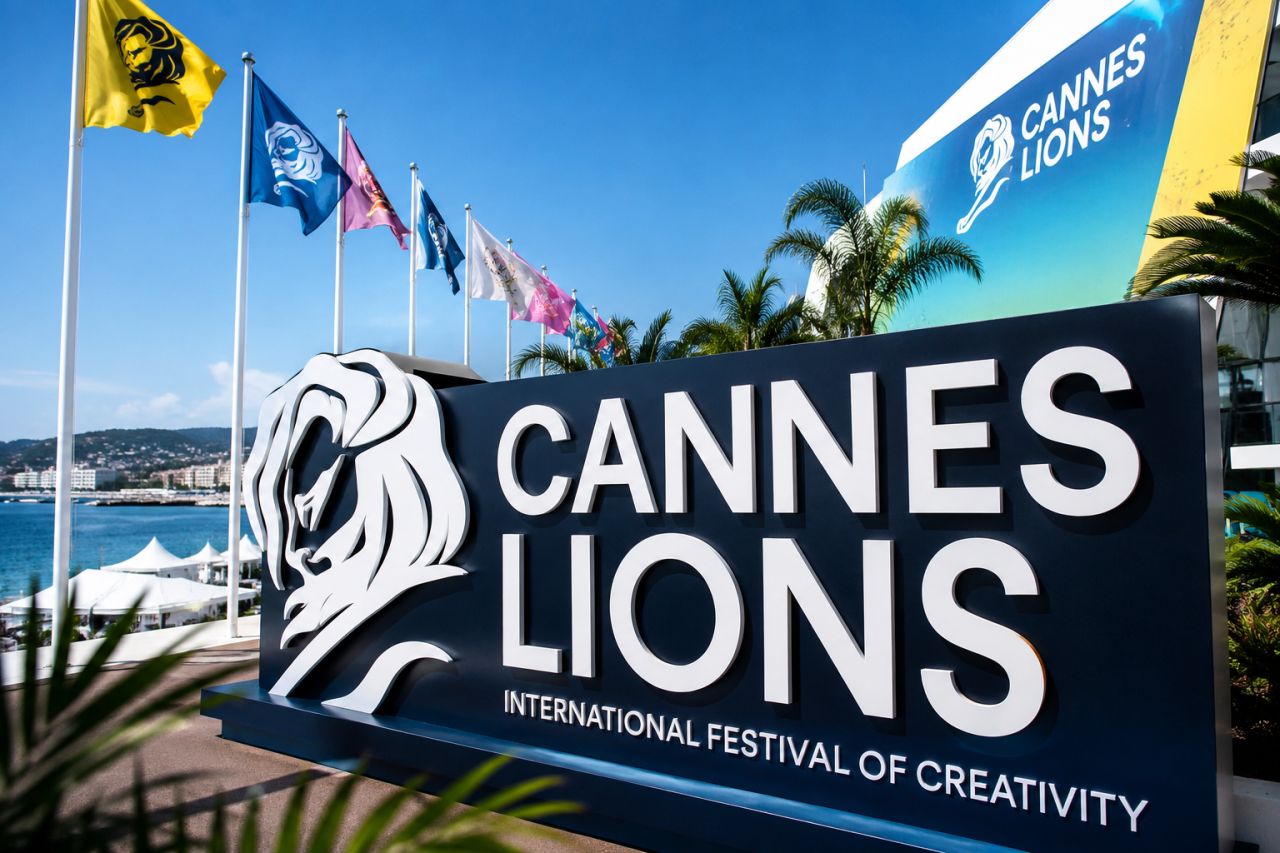 A large sign with a lion on it reading Cannes Lions Festival of Creativity with flags in the background